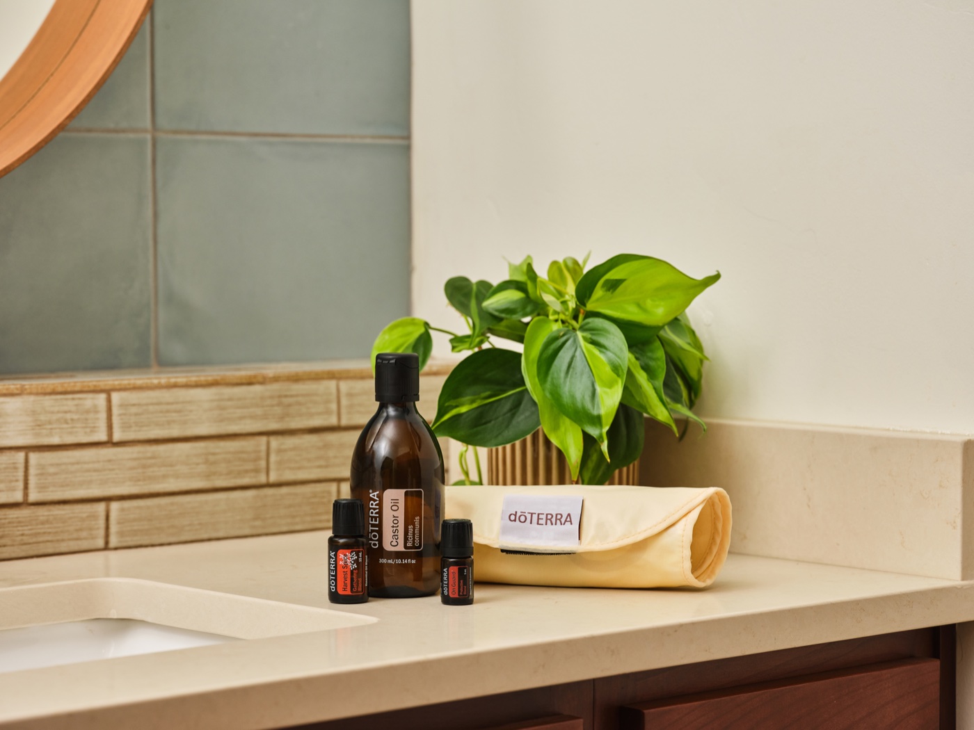 doTERRA Harvest Spice, Castor Oil, and On Guard on a bathroom counter next to a diffuser roll